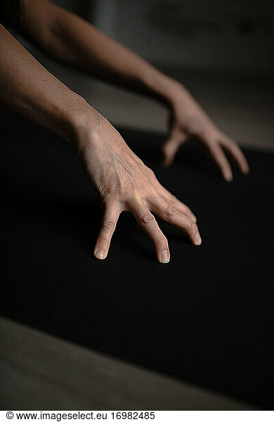 Closeup of woman hands doing yoga on the yoga mat indoor