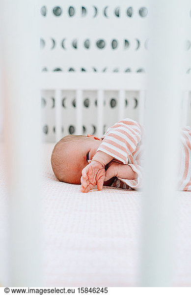 Closeup portrait of a baby girl laying in a modern crib