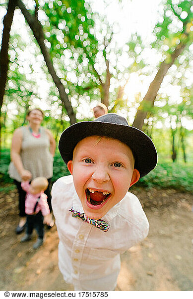 Closeup portrait of a boy laughing with his family in the background