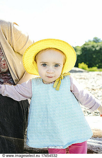 Closeup portrait of a young toddler girl in a sun hat on the beach