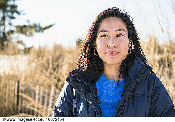 Closeup Portrait of Asian Woman outdoors smiling at the beach
