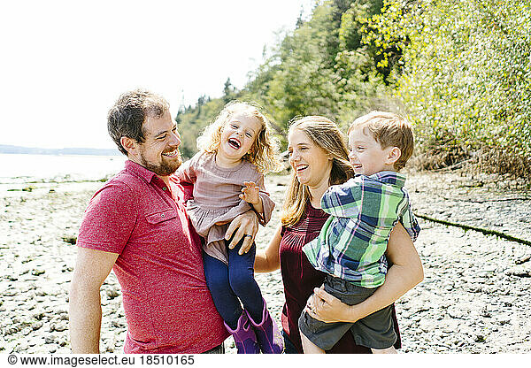 Closeup straight on portrait of a happy family of four on the beach