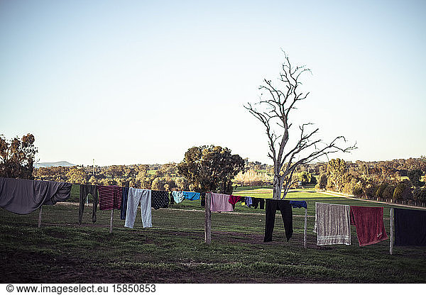 clothes dry on fence line as sun sets on farm land in Austalia