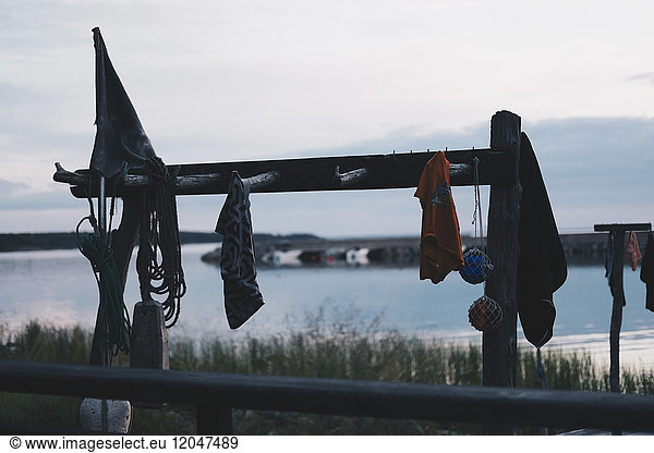 Clothes hanging on wooden rack against lake