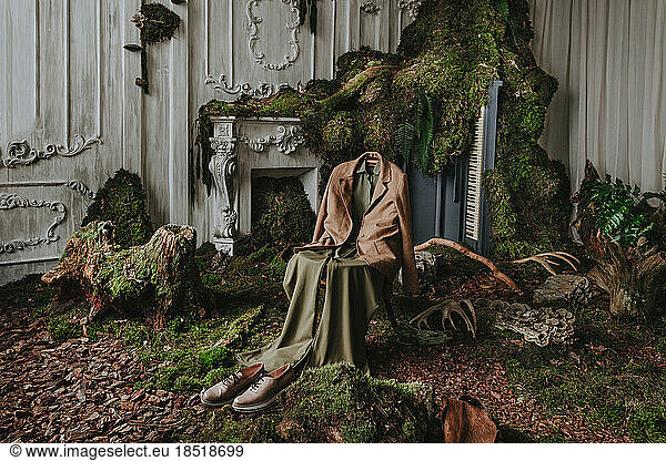 Clothes on chair with moss in abandoned place