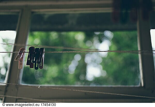 Clothespins hanging on clothesline on old balcony  blurry background