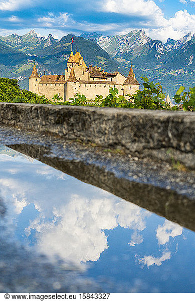 Clouds on Aigle Castle mirrored in a pond  canton of Vaud  Switzerland