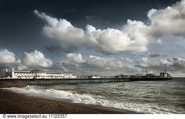 Clouds over boardwalk and beach  Brighton  Sussex  England