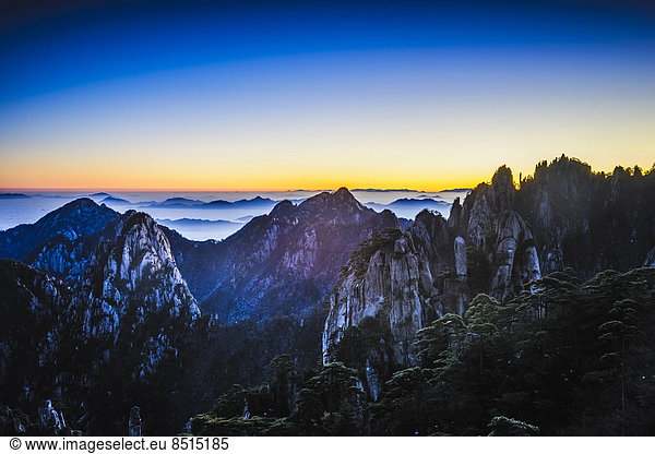 Clouds rolling over rocky mountains  Huangshan  Anhui  China