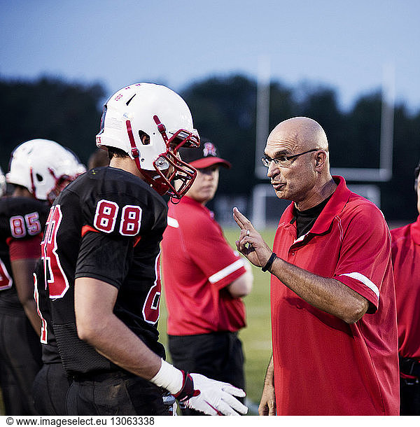 Coach explaining American football players on field