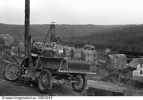 COAL TOWN  1939. A dilapidated automobile left on a hill above impovished homes in the coal town of Kempton  West Virginia. Photograph by John Vachon in May 1939.