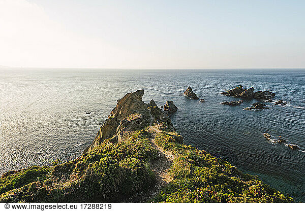 Coastal cliffs at sunset with clear line of horizon over sea in background