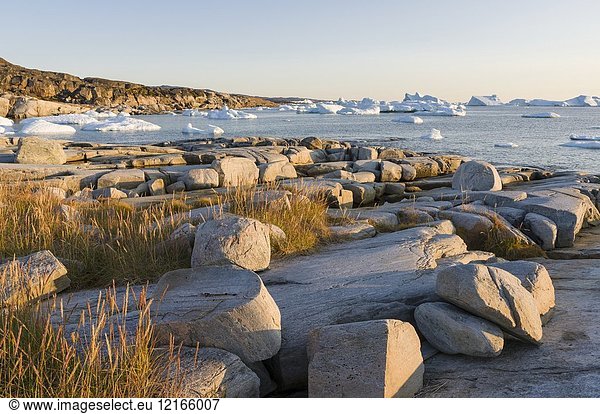 Coastal landscape with Icebergs. The Inuit village Oqaatsut (once called Rodebay) located in the Disko Bay. America,  North America,  Greenland,  Denmark.