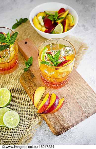 Cocktail mit Pfirsich  Minze und Limette und Eiswürfeln