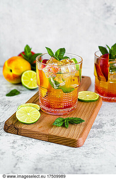 Cocktail with peach  mint and lime and ice cubes