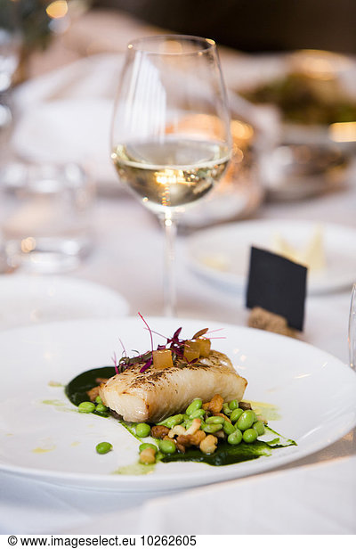 Cod with Lima Beans and Glass of White Wine at Wedding Reception