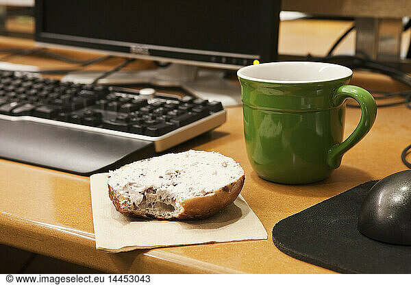 Coffee Cup and Bagel on a Desk