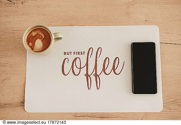 Coffee cup and mobile phone over table