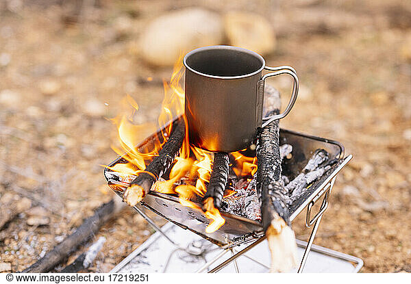 Coffee mug on burning firewood