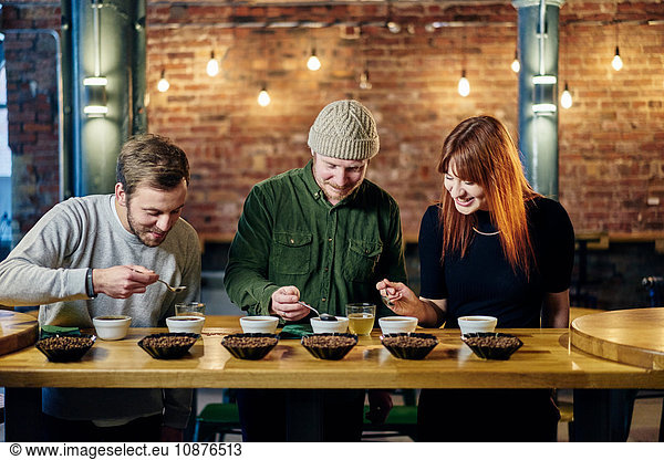 Coffee shop team tasting bowls of coffee and coffee beans
