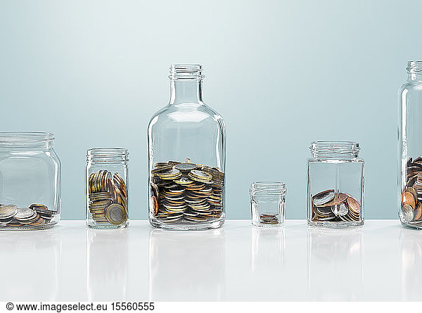 Coins in variety of glass bottles