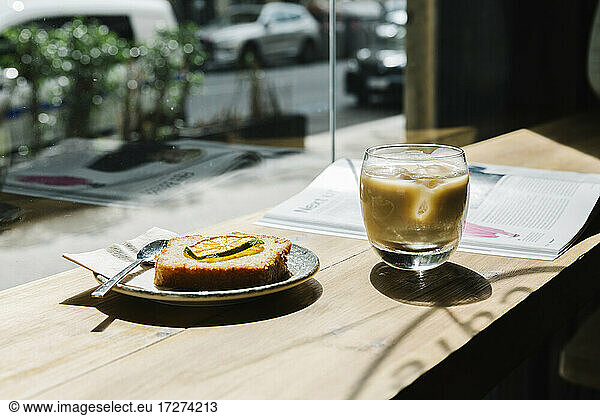Cold brew coffee and cake on table at coffee shop