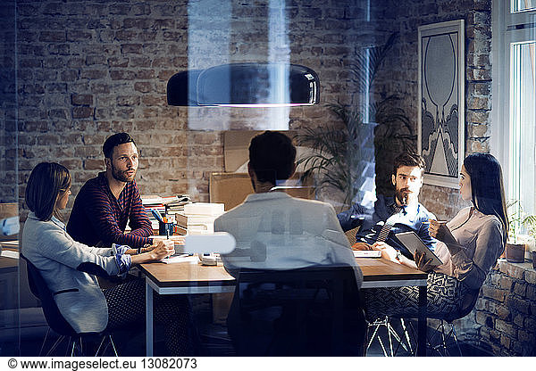 Colleagues having discussion at table in conference room
