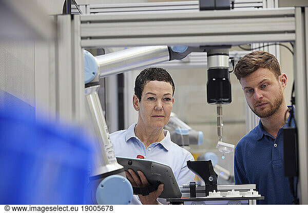 Colleagues working together in modern robotic factory
