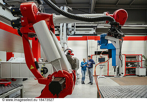 Colleagues working together in robot factory