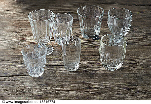Collection of empty glasses standing on wooden surface