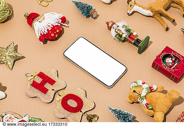 Collection of various old-fashioned Christmas decorations surrounding modern smart phone