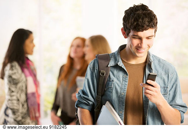 College student text messaging with cell phone