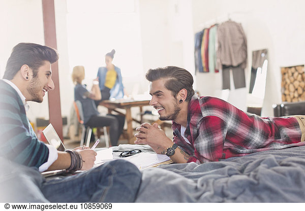College students studying on bed in apartment