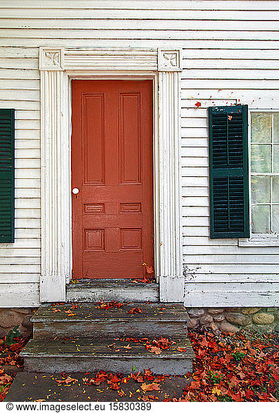 Colonial Home with Orange Door in the Fall Season