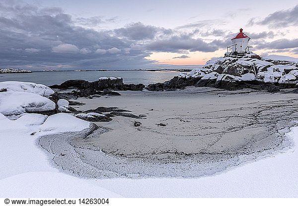 Colorful arctic sunset on the lighthouse surrounded by snow and icy sand Eggum Vestvagoy Island  Lofoten Islands  Norway  Europe