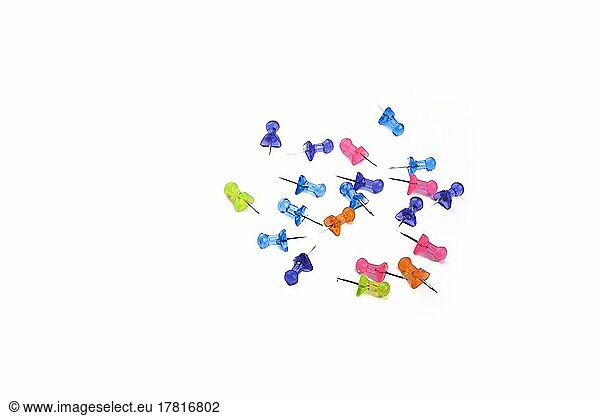 Colorful drawing-pins scattered on a white background