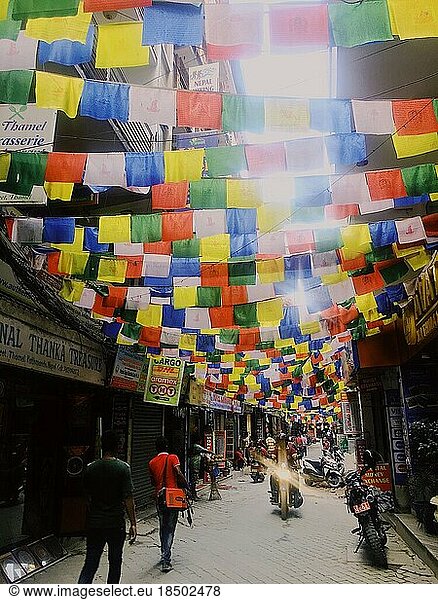Colorful Himalayan flags over busy street in Southeast Asia