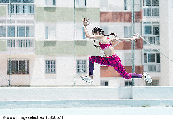 Colorful image of full body of female athlete jumping on court