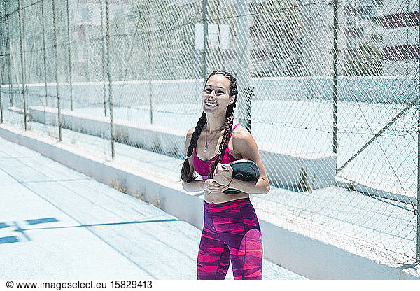 Colorful image of upper body of female athlete holding weight on court