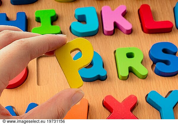 Colorful Letter of Alphabet P made of wood in hand