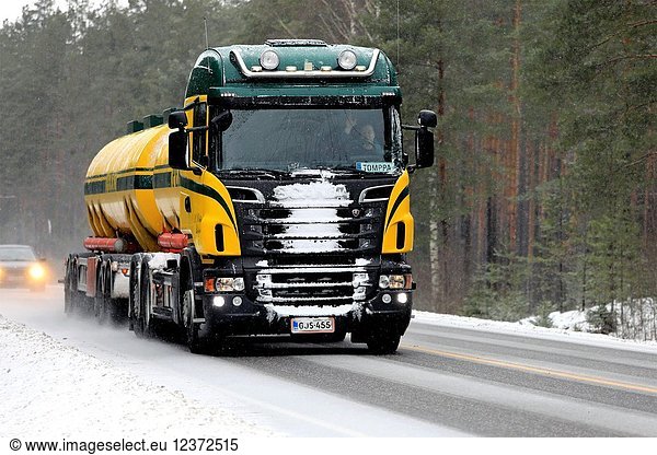 Colorful Scania R500 tank truck of Kuljetusliike K. Pekki transports goods on rural highway during heavy snowfall. Snow gathers on grille of the vehicle. Salo  Finland - February 3  2018.