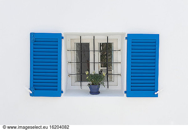 Colorful shutters and flowers in window