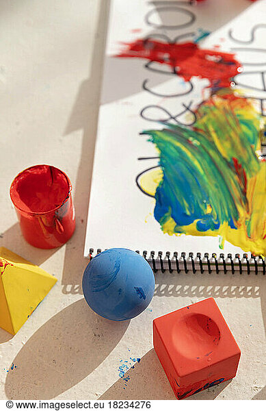 Colorful toy blocks and note pad covered in paint