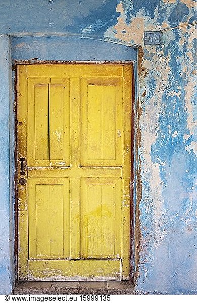 Colours  shapes and textures at the decayed fa?ade of crumbling plaster and weathered wooden door. Gibara  Cuba.