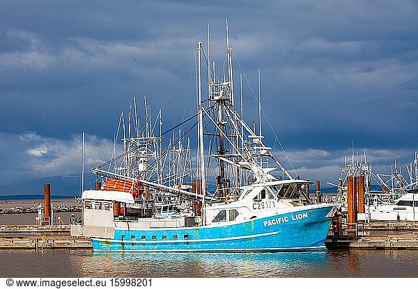 Commercial fishing vessel in Steveston Harbour against dark skies of an approaching storm.