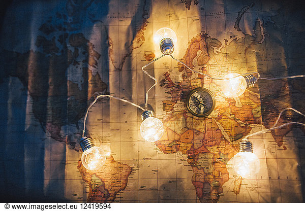 Compass and fairy lights on world map