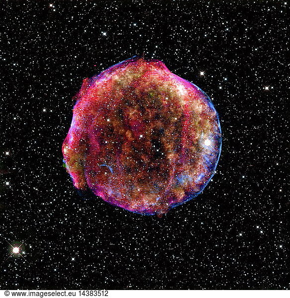 composite image of the Tycho supernova remnant combines infrared and X-ray observations obtained with NASA"s Spitzer and Chandra space observatories  respectively  and the Calar Alto observatory  Spain. It shows the scene more than four centuries after the brilliant star explosion witnessed by Tycho Brahe and other astronomers of that era. The explosion has left a blazing hot cloud of expanding debris (green and yellow). The location of the blast"s outer shock wave can be seen as a blue sphere of ultra-energetic electrons. Newly synthesized dust in the ejected material and heated pre-existing dust from the area around the supernova radiate at infrared wavelengths of 24 microns (red). Foreground and background stars in the image are white.