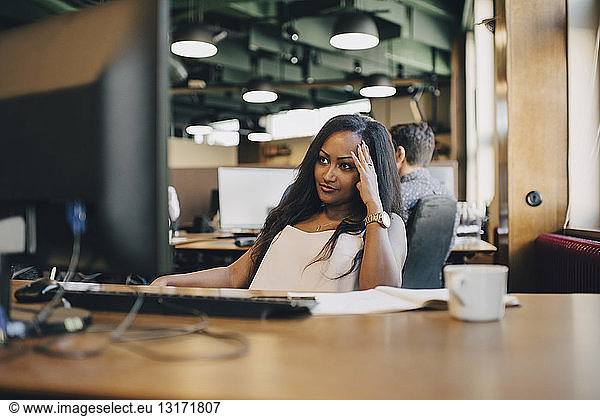 Concentrated businesswoman looking at computer monitor in office