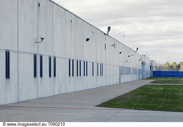 Concrete Building  Prison Yard  and surveillance cameras at a Correctional Facility. Prison unit or wing.