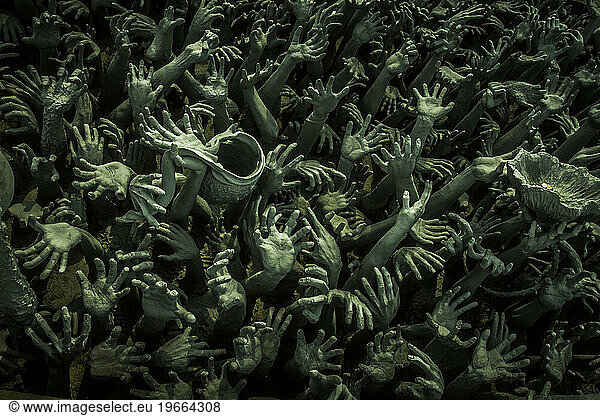 Concrete hands reaching up from the ground
